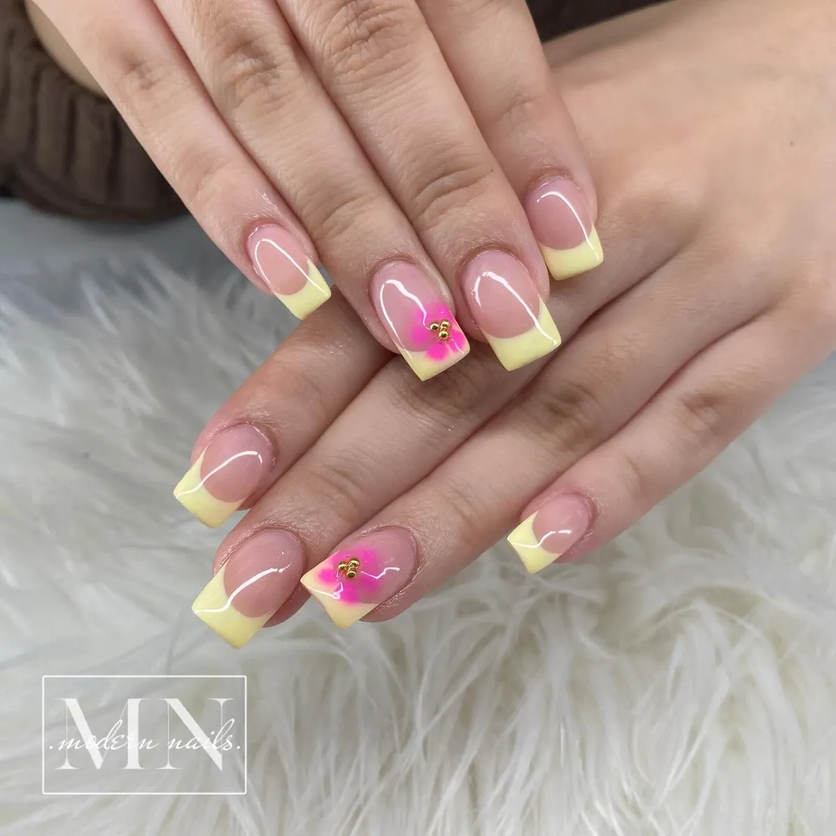 Soft yellow French tips with pink flower accents