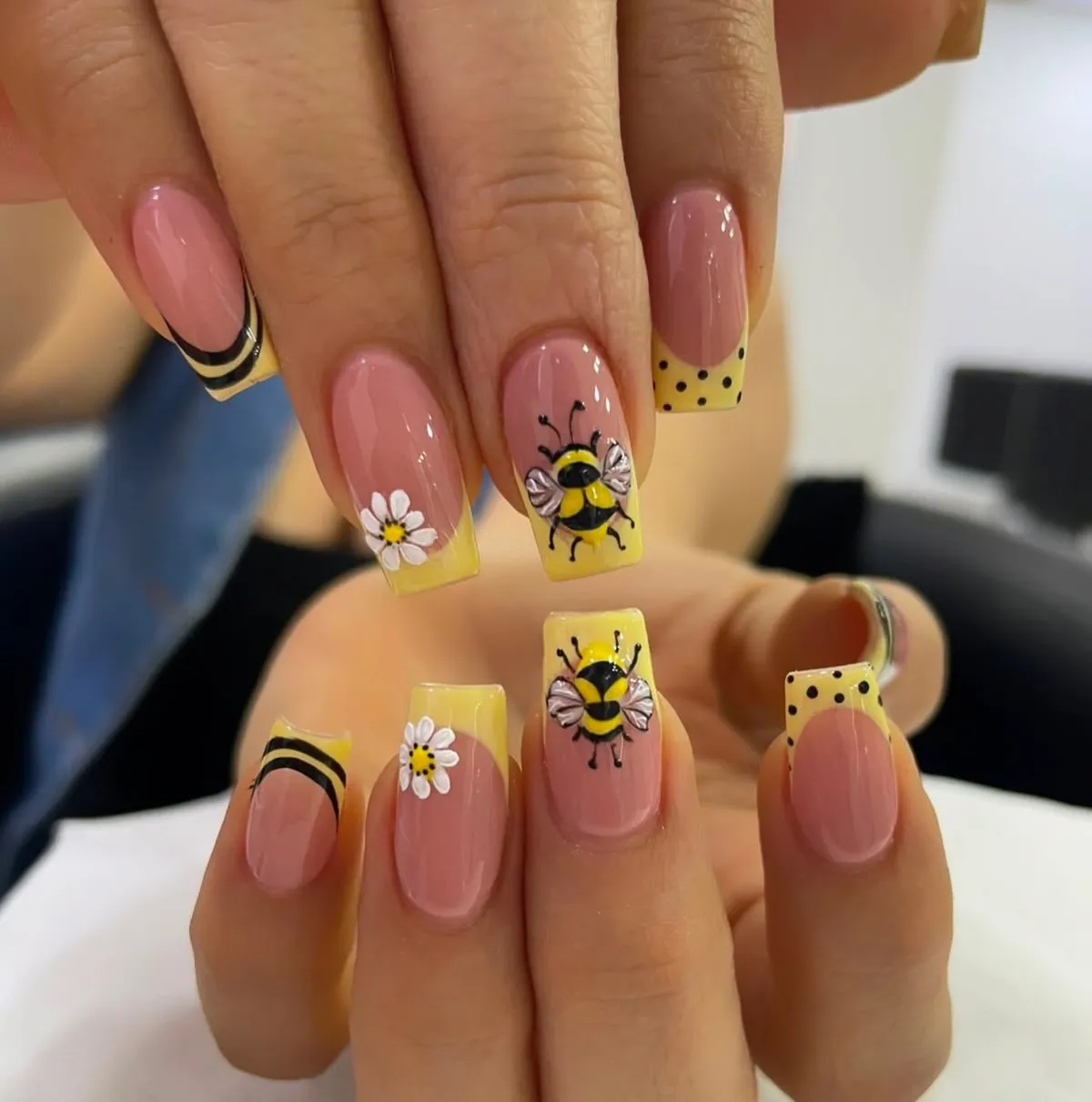 Yellow French tips with bees, daisies, and black accents
