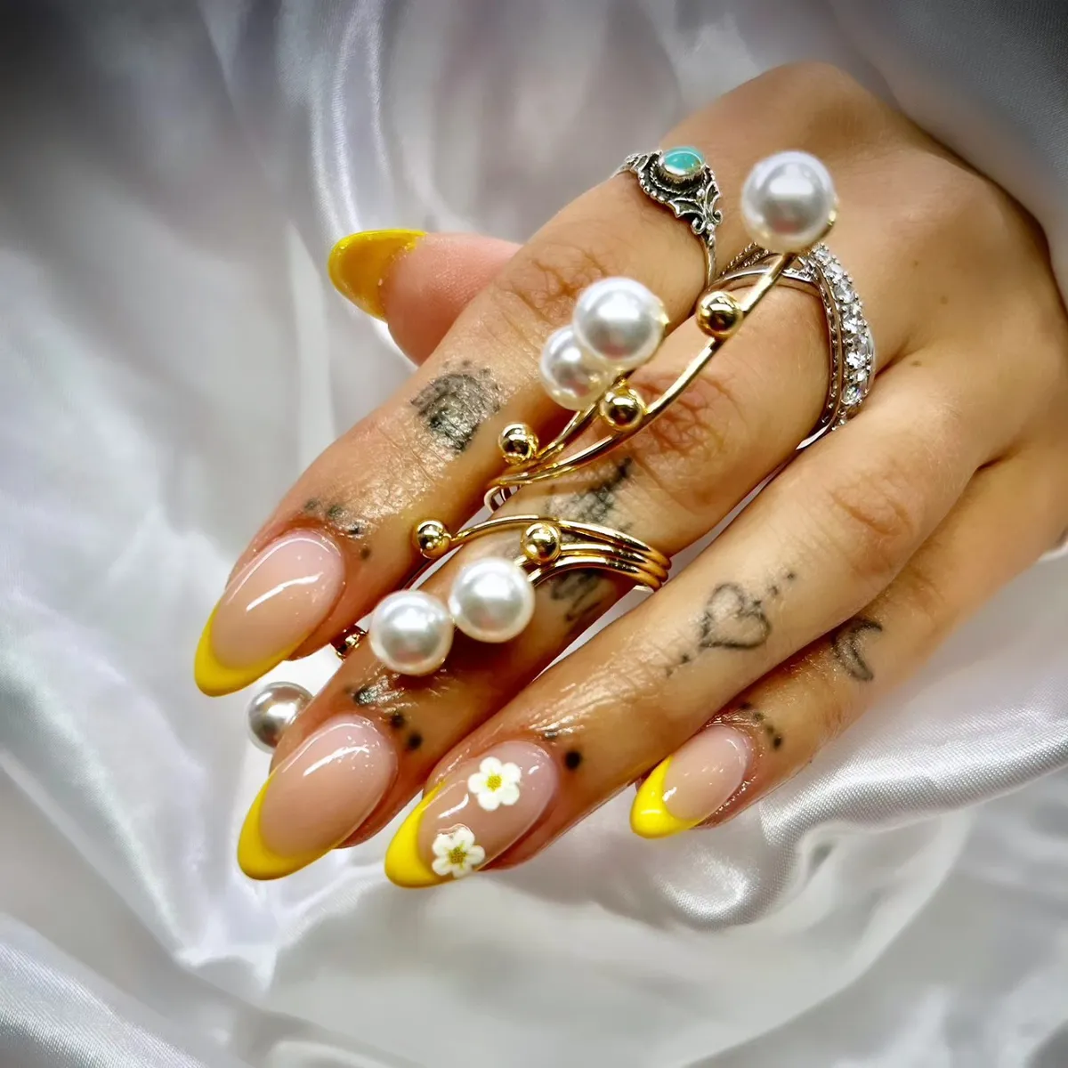 Bright yellow French tips with small white floral accents