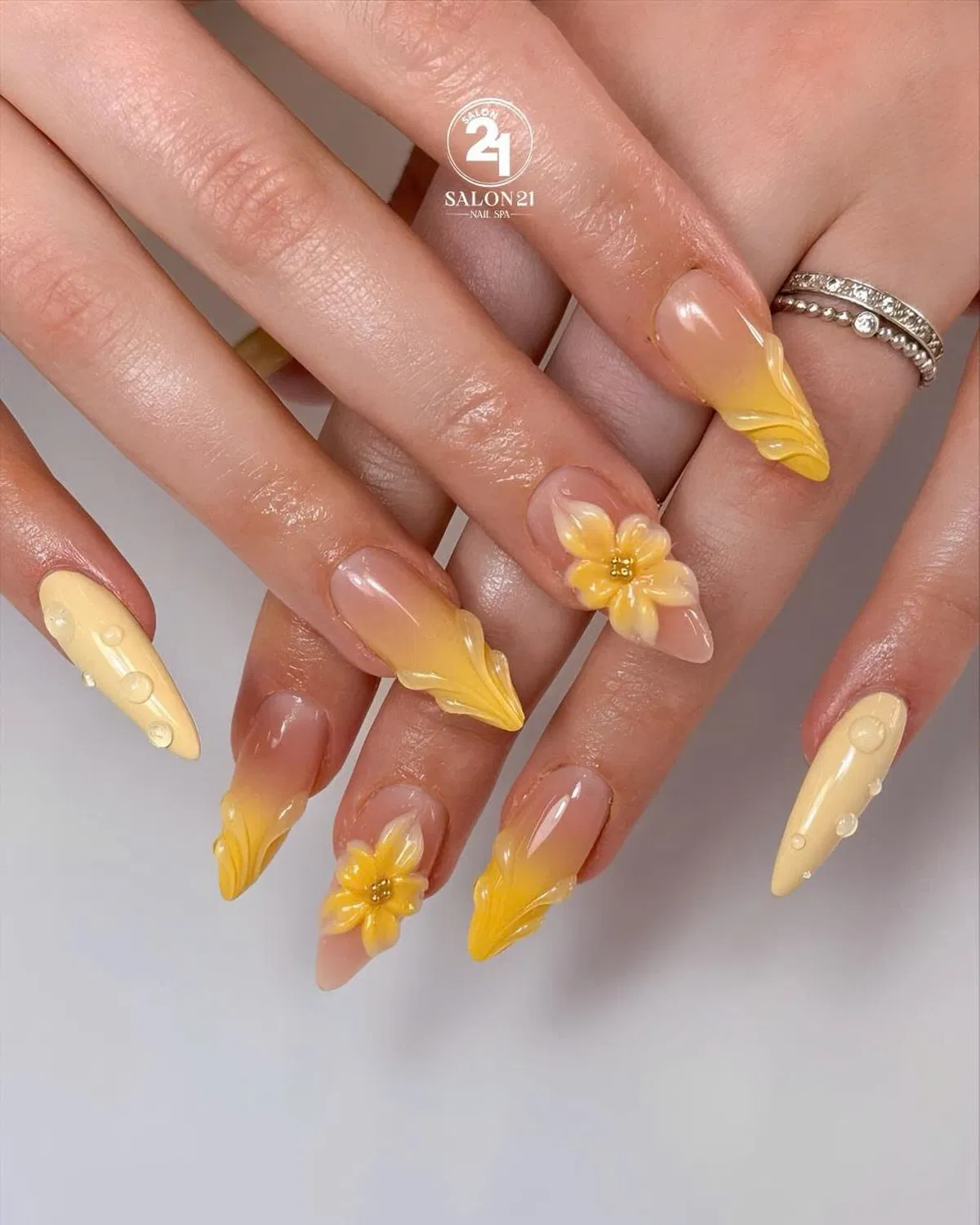 Nude-to-yellow ombre with raised flowers and wavy tips