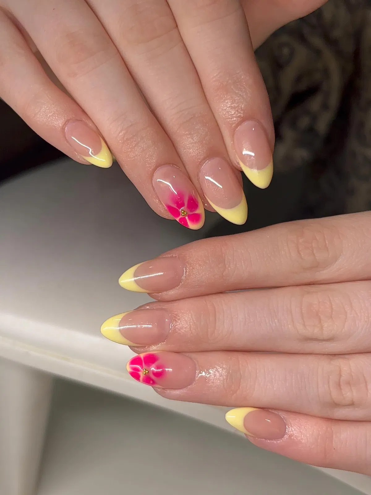 Pale yellow French tips with hot-pink flower accents