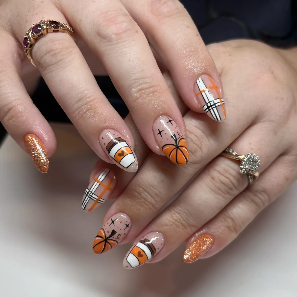Orange glitter, plaid linework, pumpkin art, and cup graphic accents