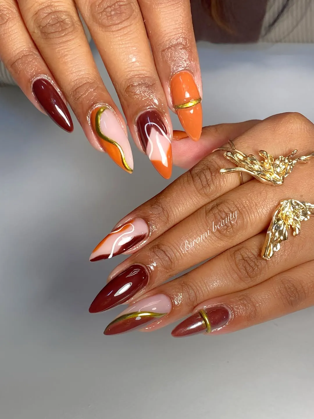 Burgundy and orange swirls with gold accents