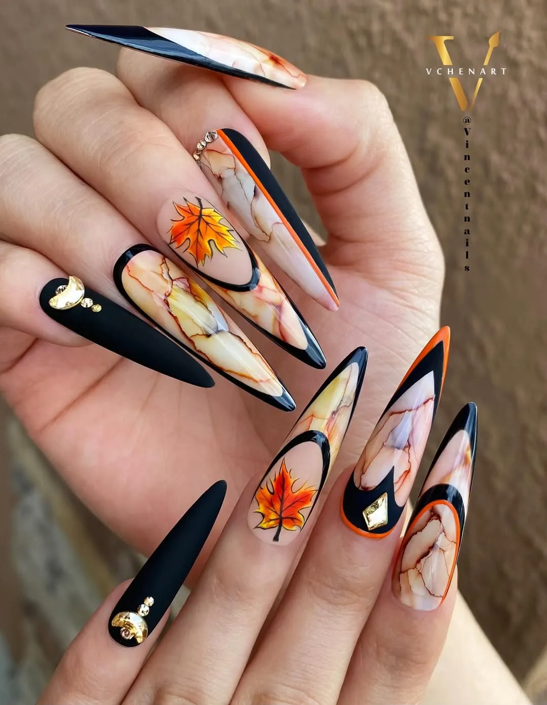 Matte black and marbled stilettos with orange leaves and gold accents