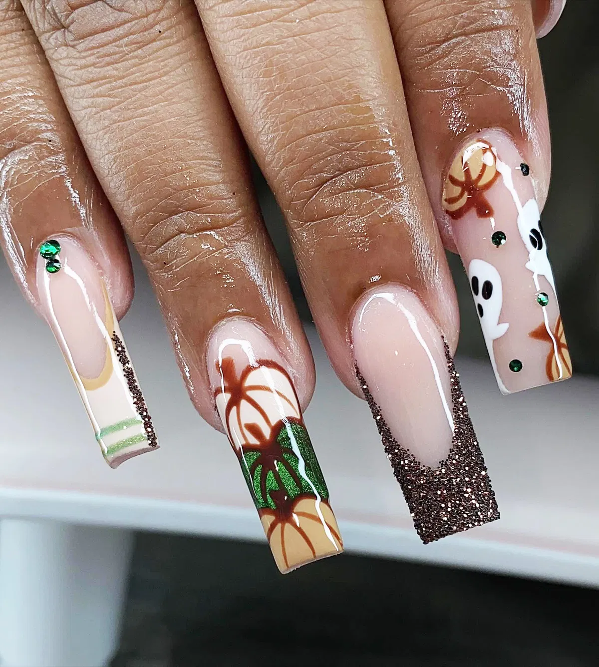 Coffin nails with glitter tips, pumpkins, and ghost art