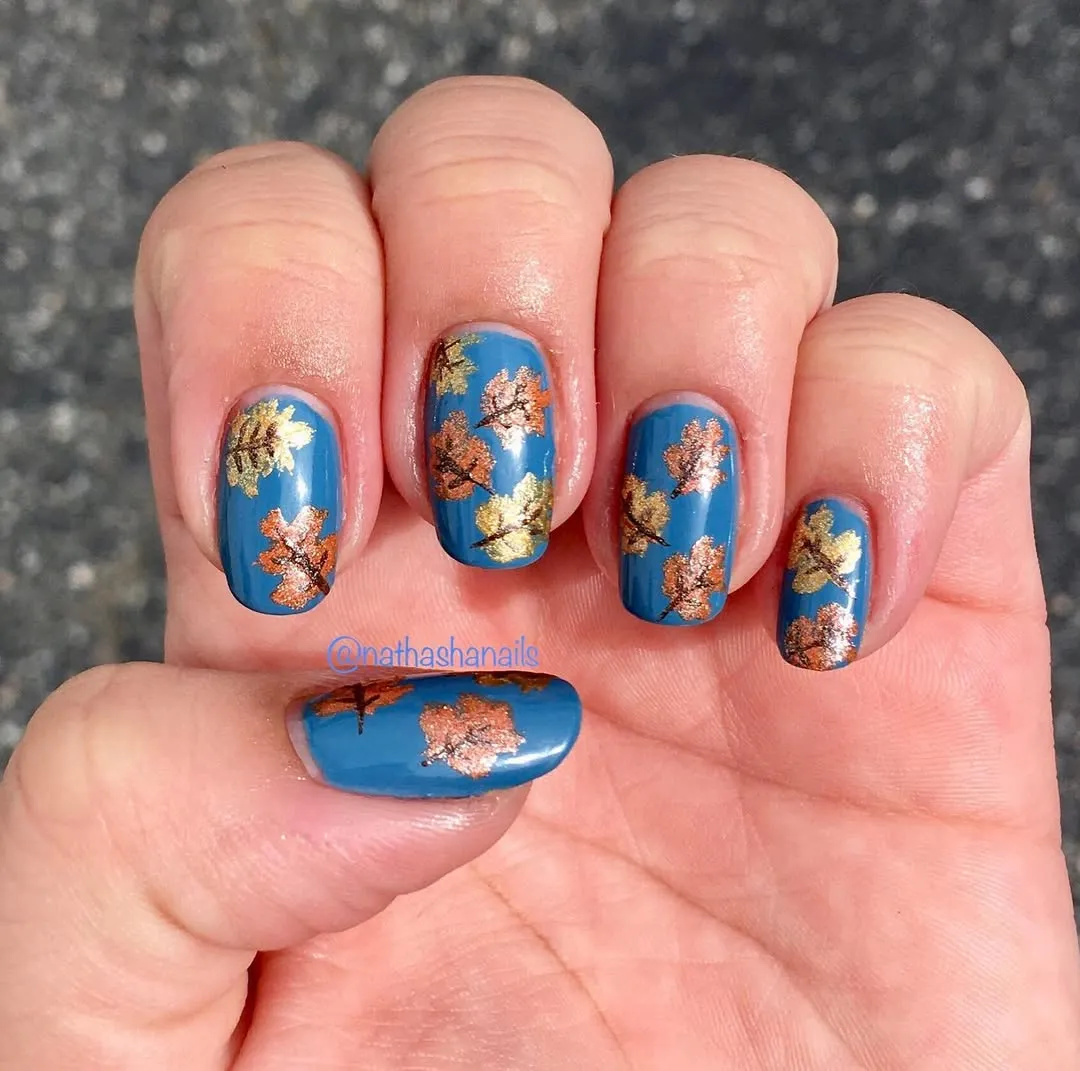 Teal-blue nails with metallic leaf motifs