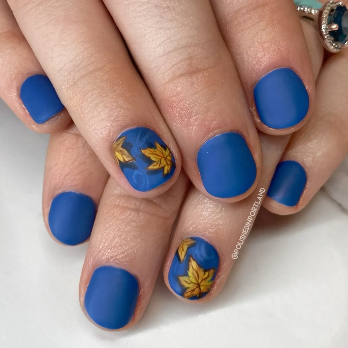 Matte blue nails with yellow leaf accents