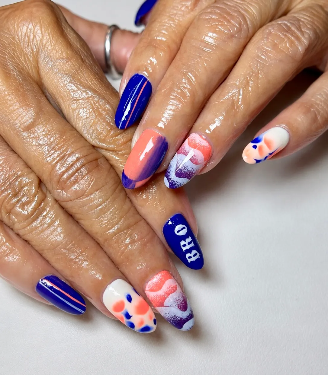Royal blue set with orange accents and “BHO” text nail