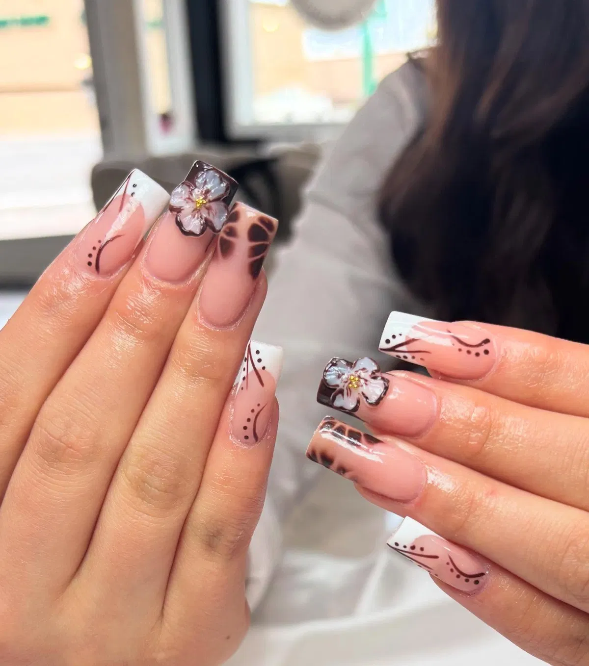 White French tips with brown linework and raised floral accents