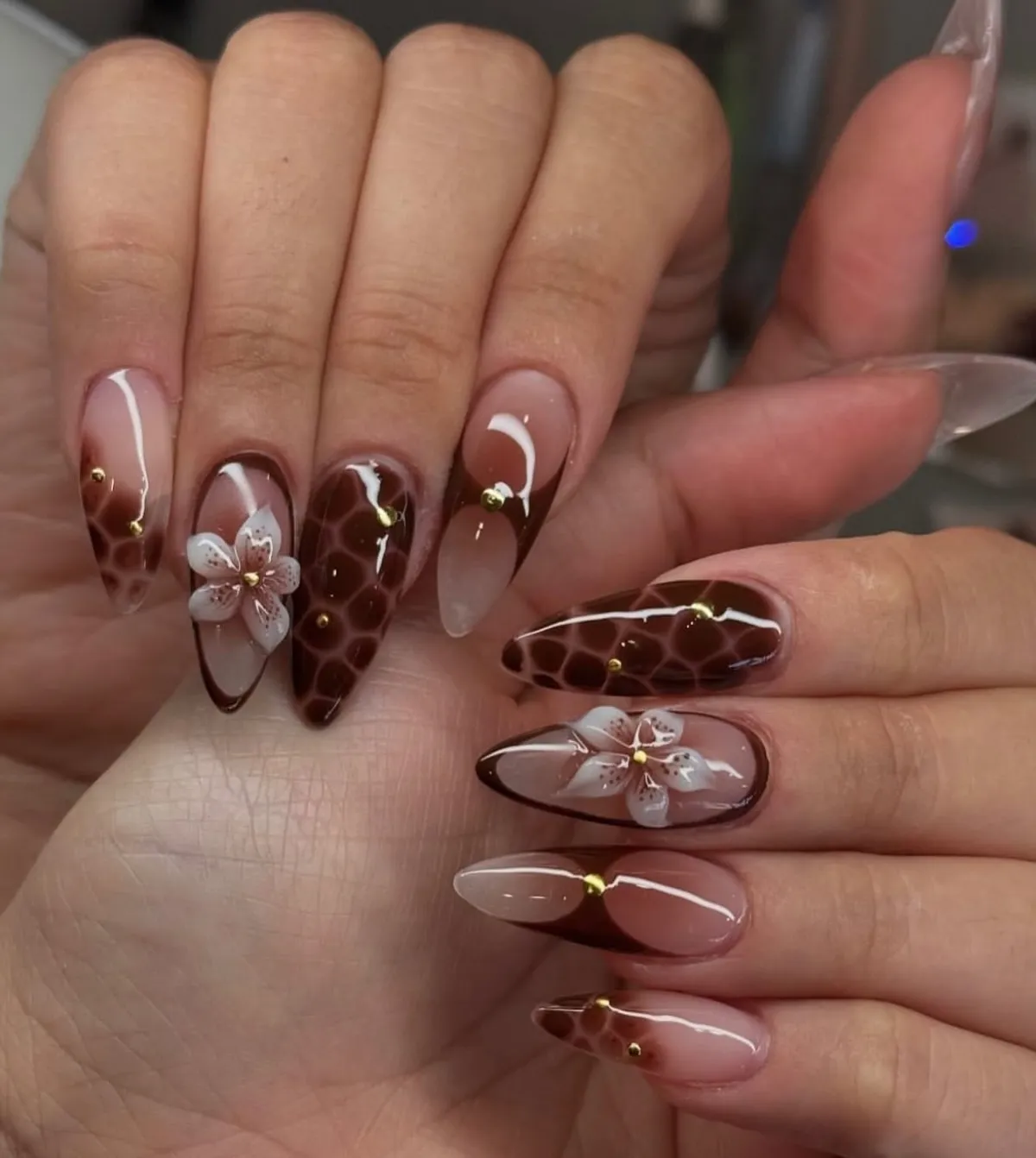 Glossy tortoiseshell almond nails with white flowers