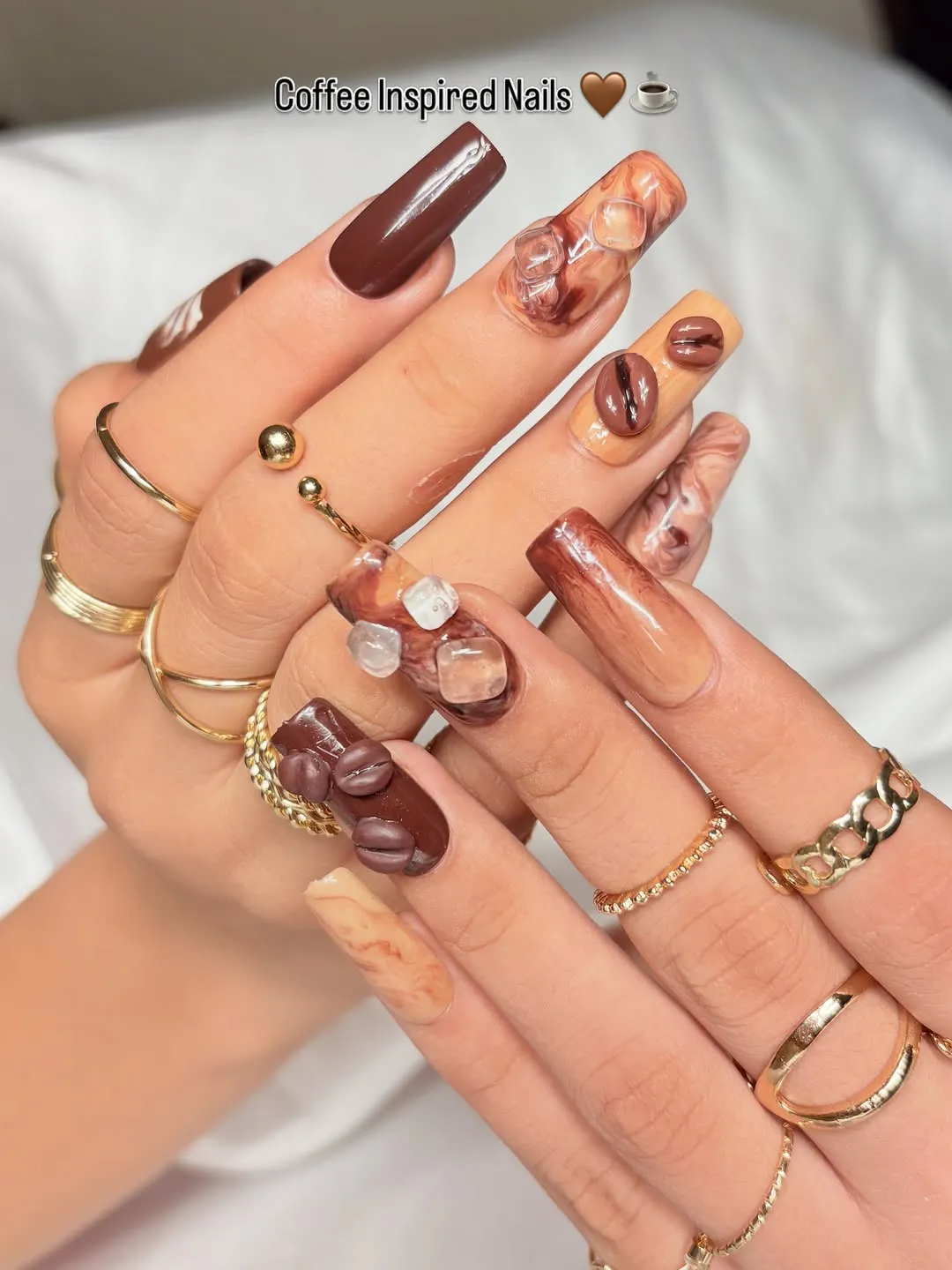 Coffee-inspired brown nails with 3D beans and clear cube embellishments