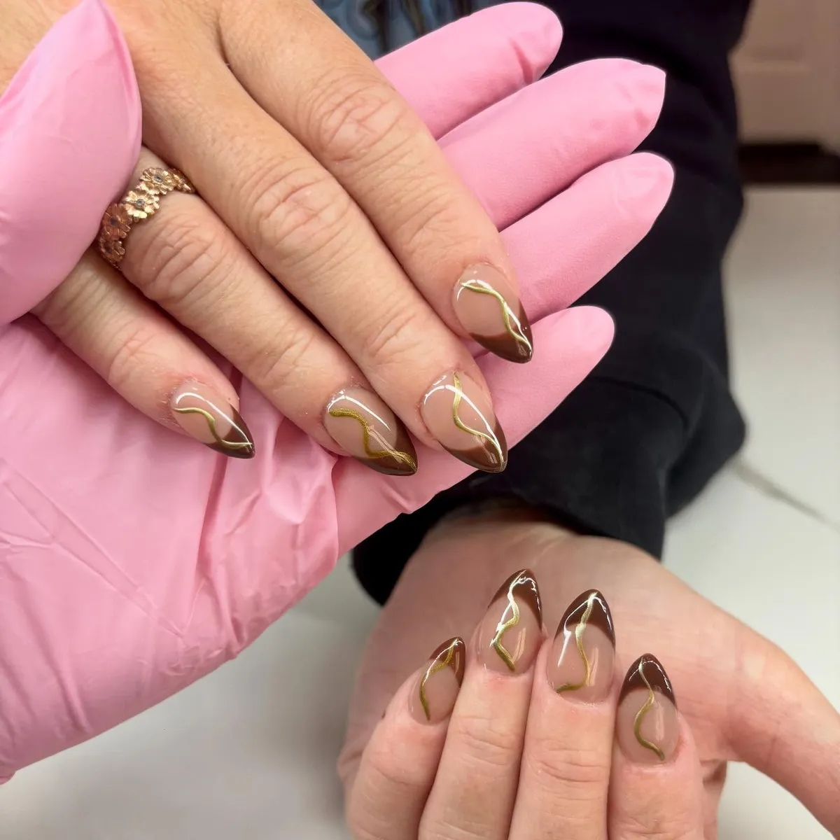 Nude nails with brown tips and wavy gold lines