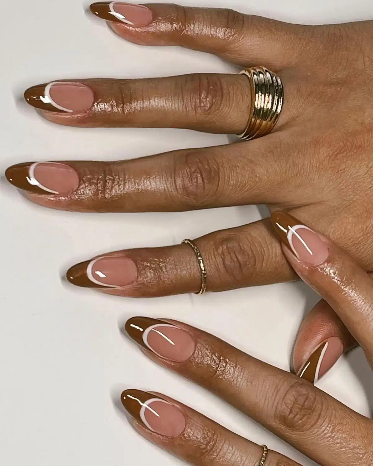 Brown French tips with white curved line accents