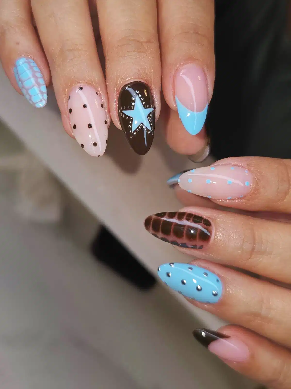 Brown accent nail with light-blue star and mixed blue details