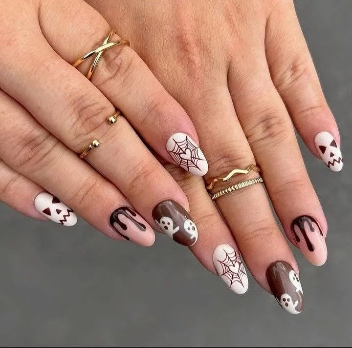 Brown and white graphic nails with drips, webs, ghosts, and skulls