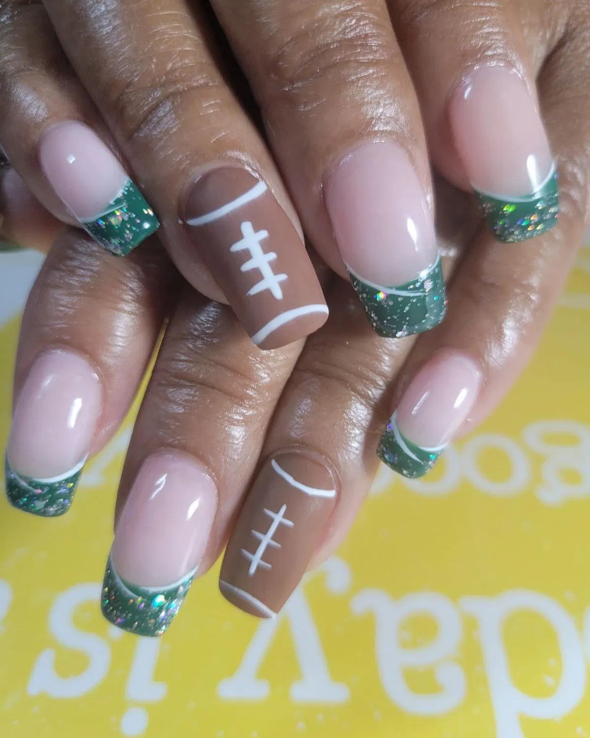 Green glitter French tips with football accent nails