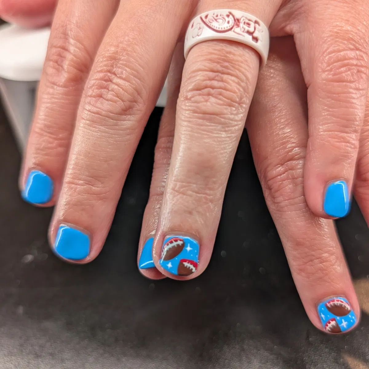 Bright blue nails with mini football accents