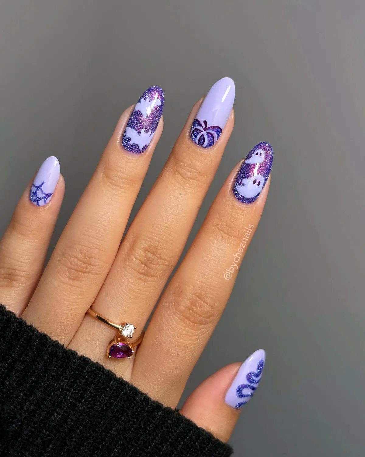 Lavender and purple glitter nails with bats, ghosts, and a pumpkin outline
