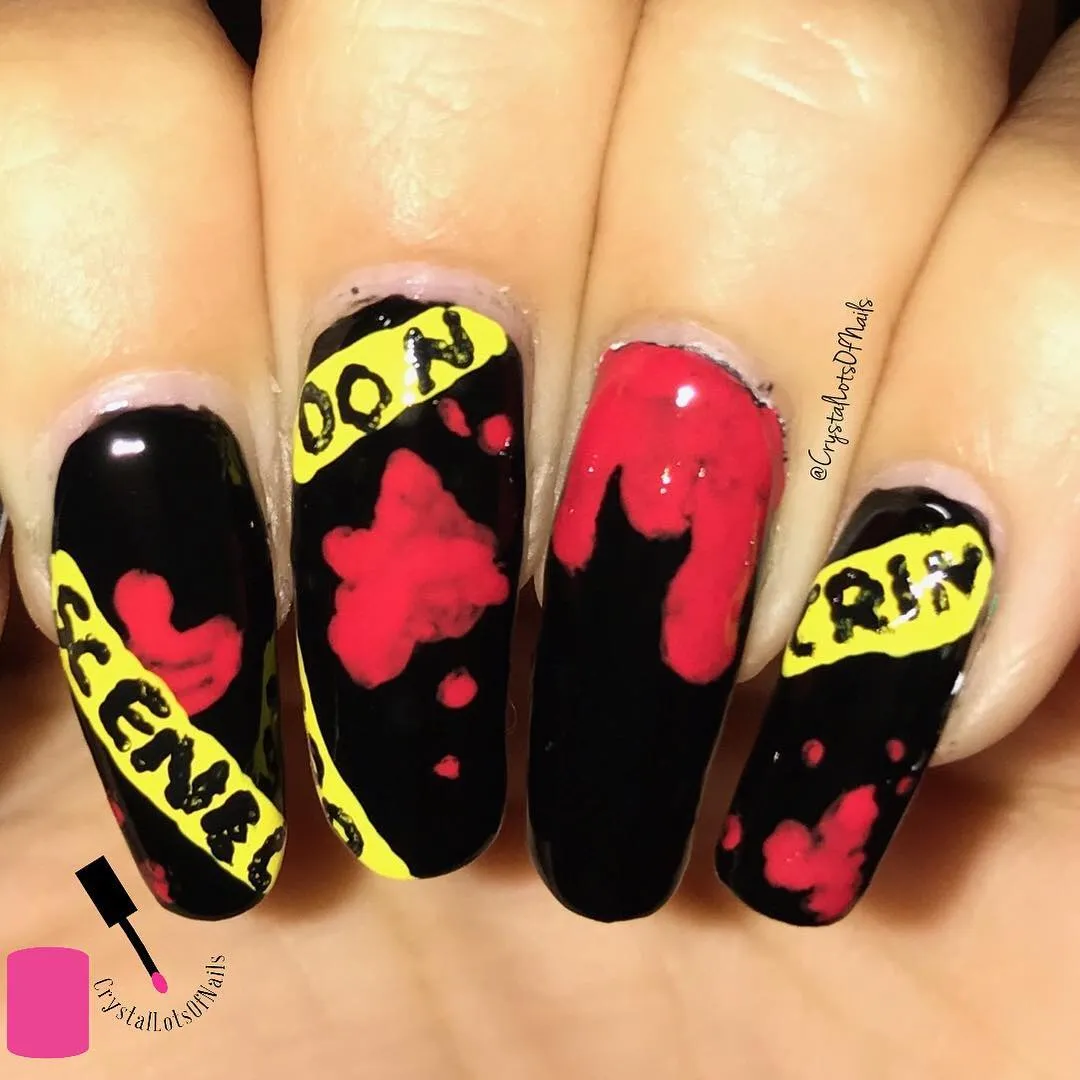 Black nails with yellow text bands and red splatter accents