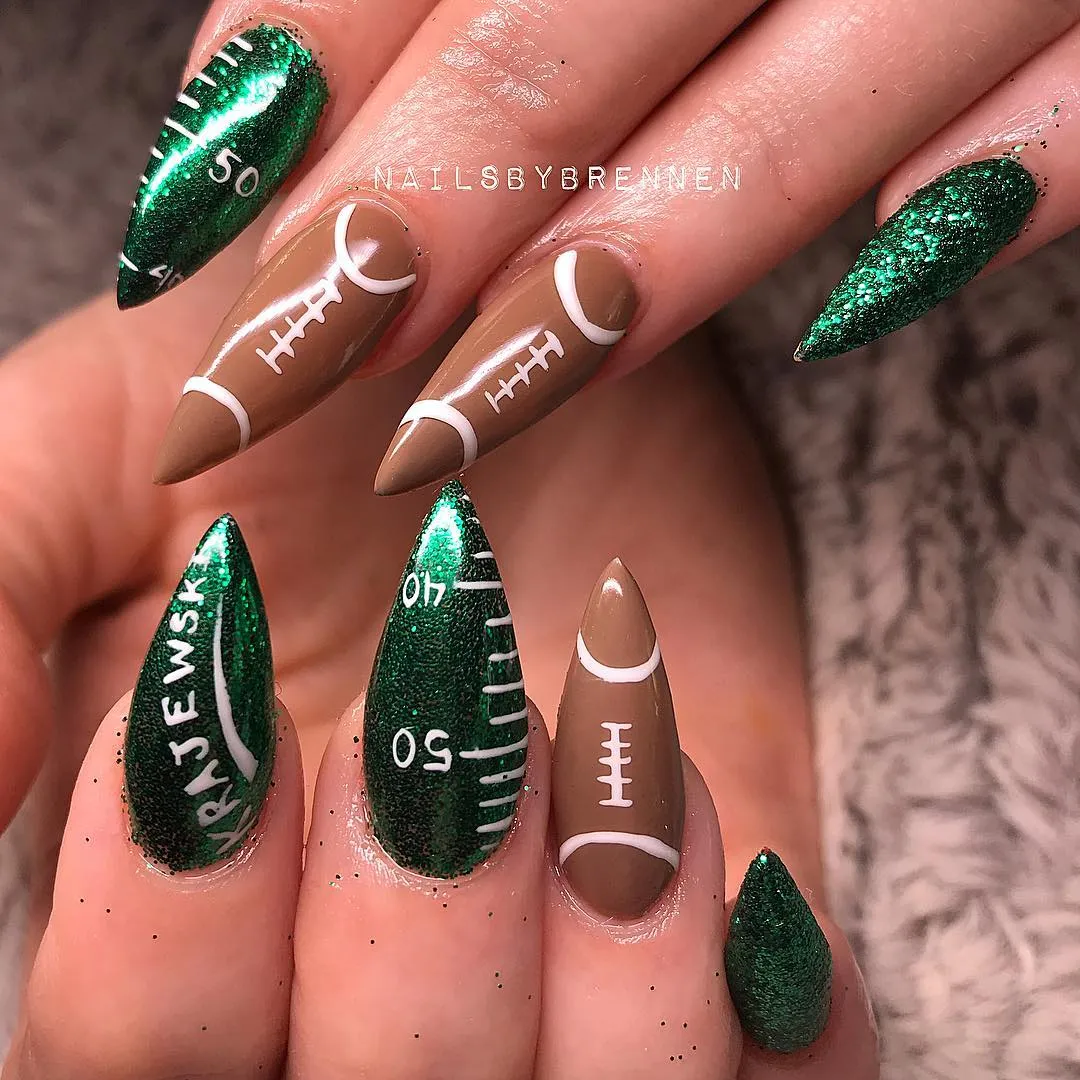 Stiletto green glitter field nails with name text and football-lace browns