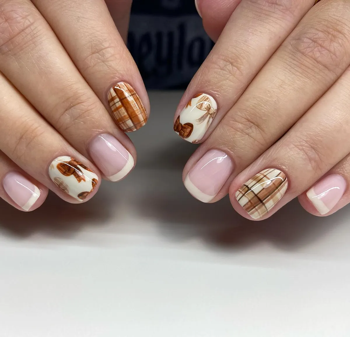 Nude French tips with brown plaid and illustrated accents