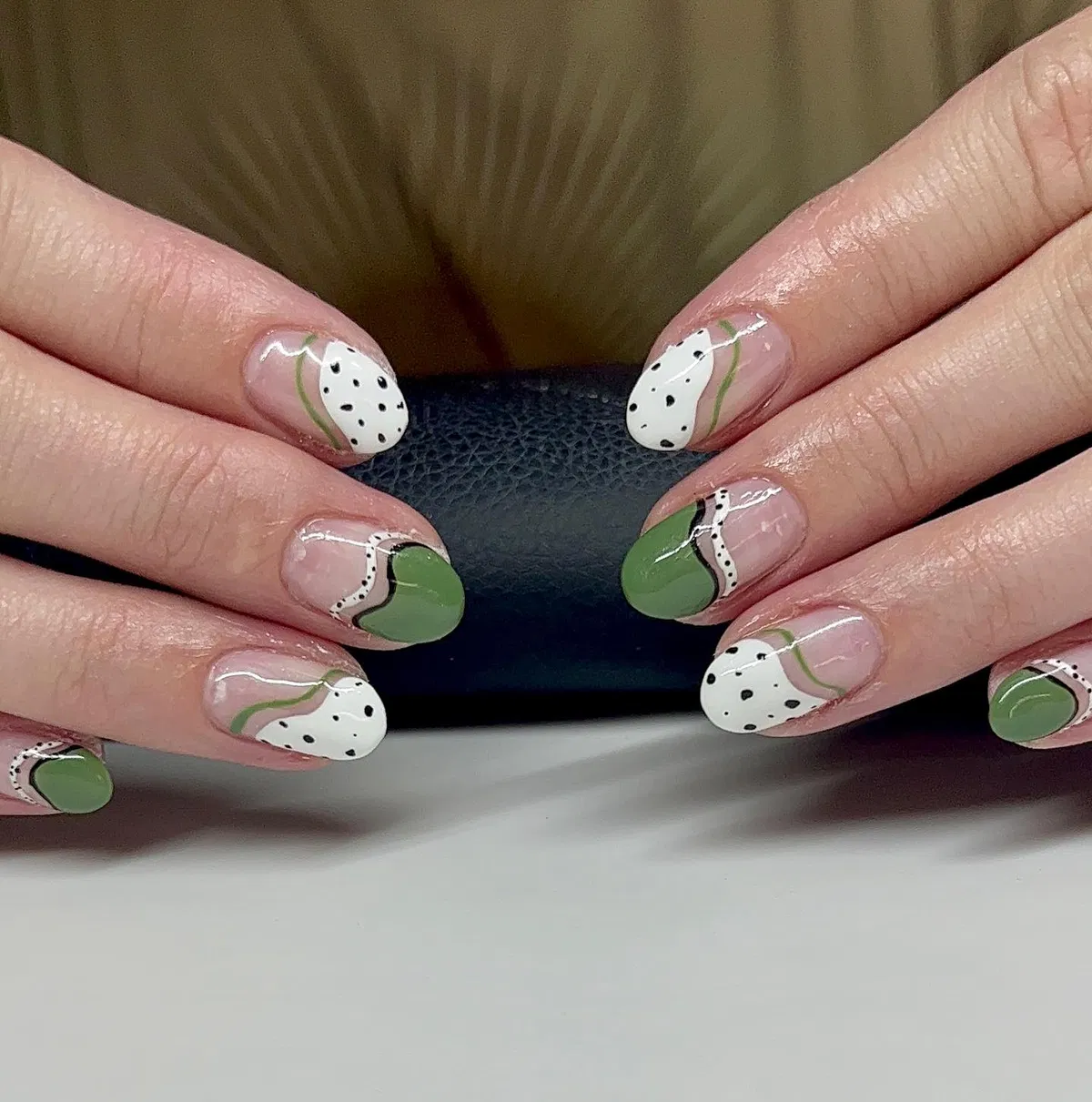 Abstract olive-green curves with dotted off-white sections