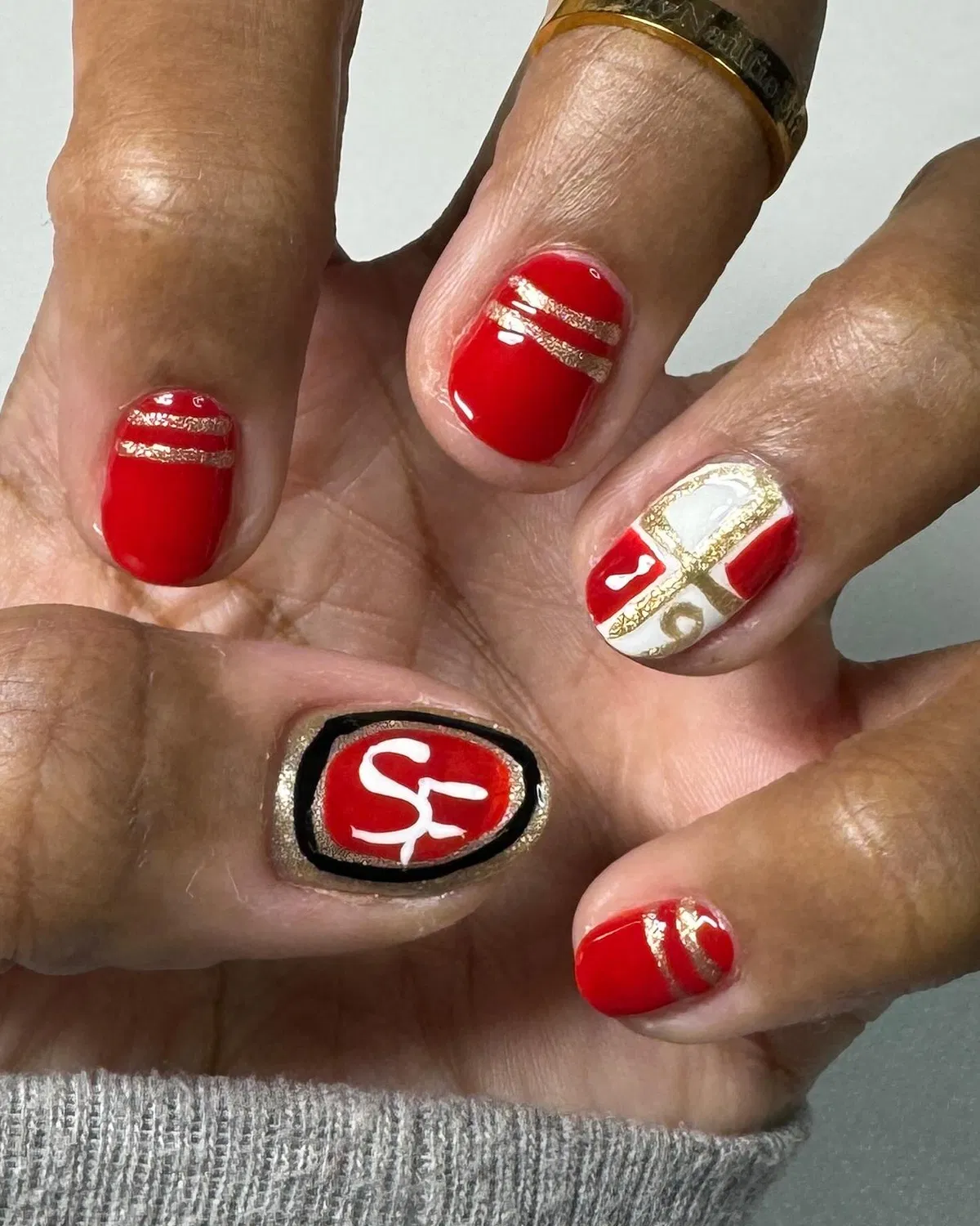 Red and gold accents with "SF" emblem nail
