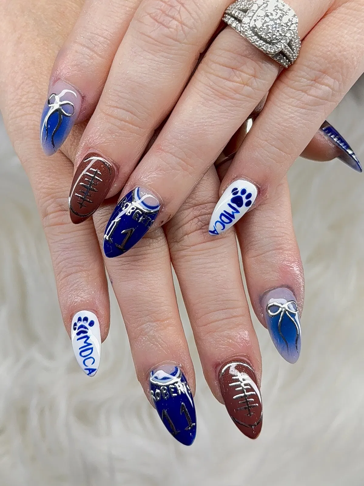 Blue “ROGERS 11” text with paw-print initials and football-lace accents