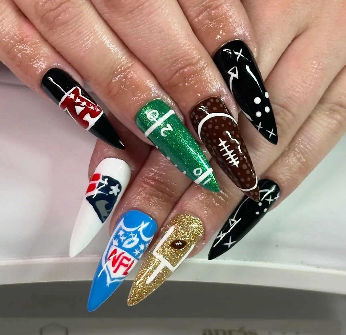 Stiletto set with playbook marks, field art, and “NFL” graphic