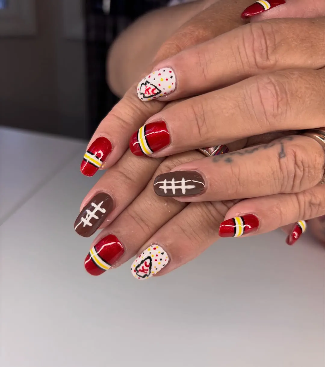 Red stripe bands with “KC” accents and football-lace nails