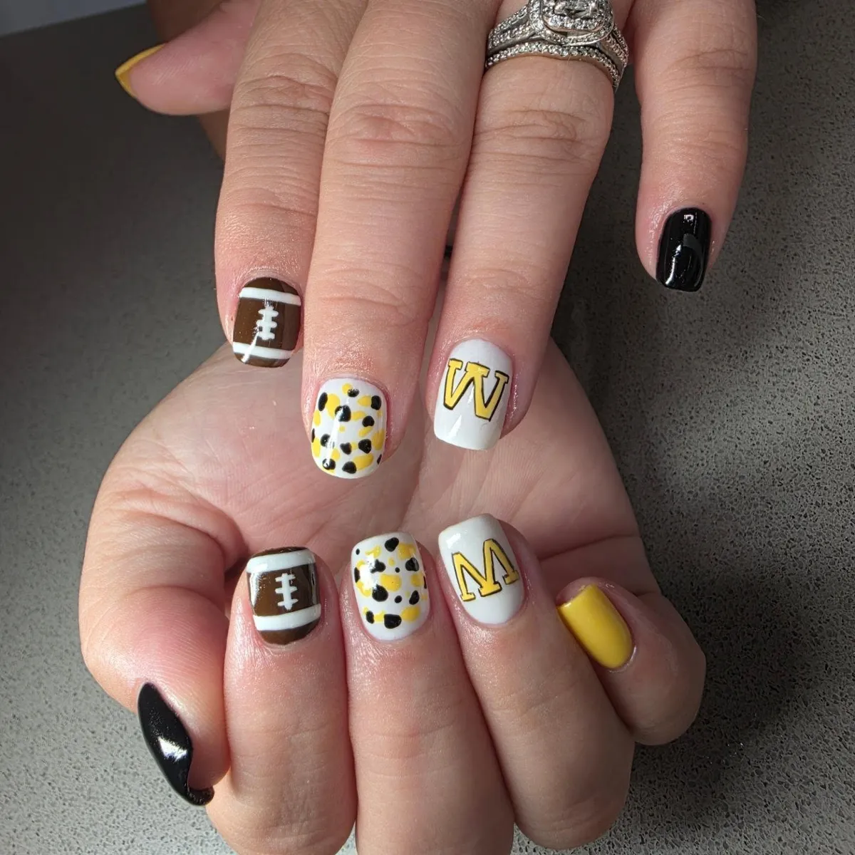 Black, yellow, and white letter nails with football accents