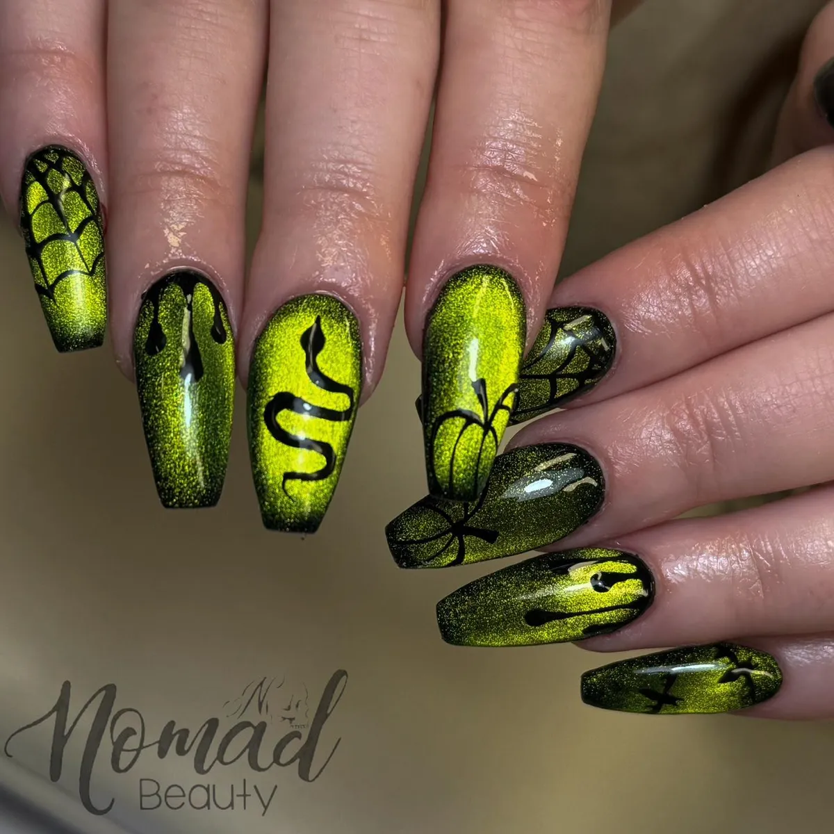Metallic yellow-green coffin nails with drips, snake curve, webs, and pumpkin outline