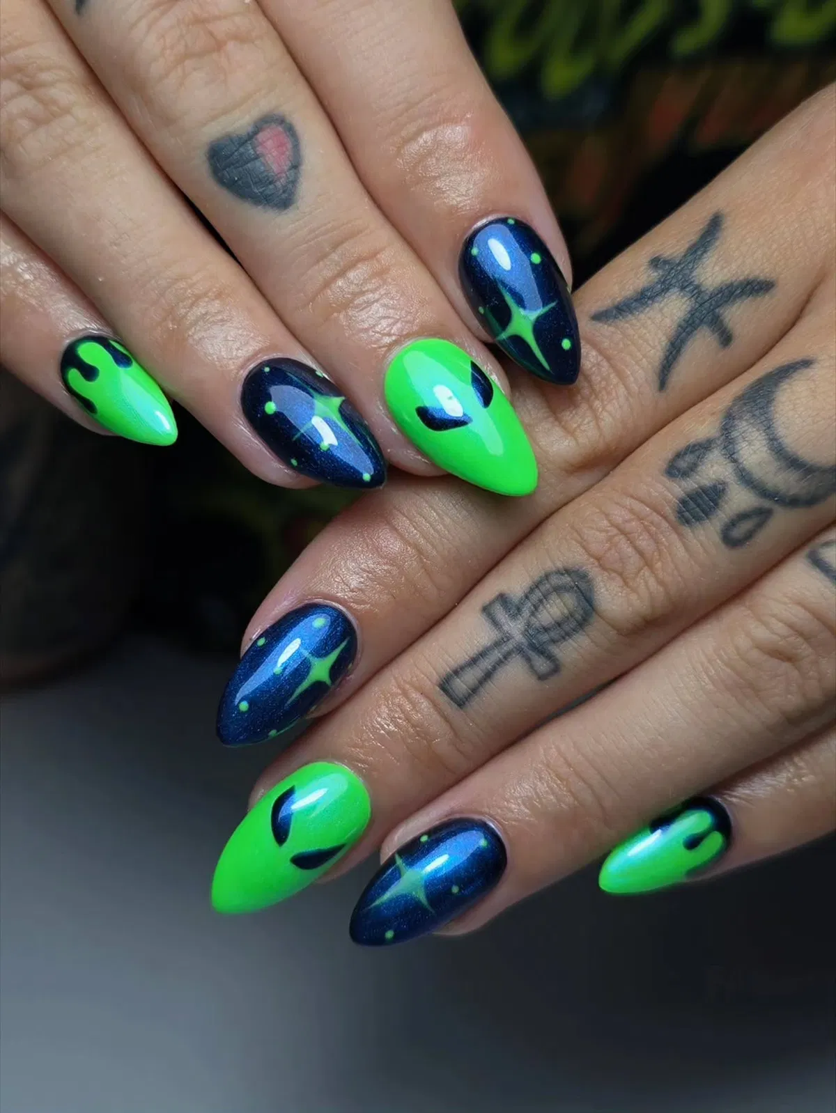Neon green alien-eye nails with dark blue starburst accents