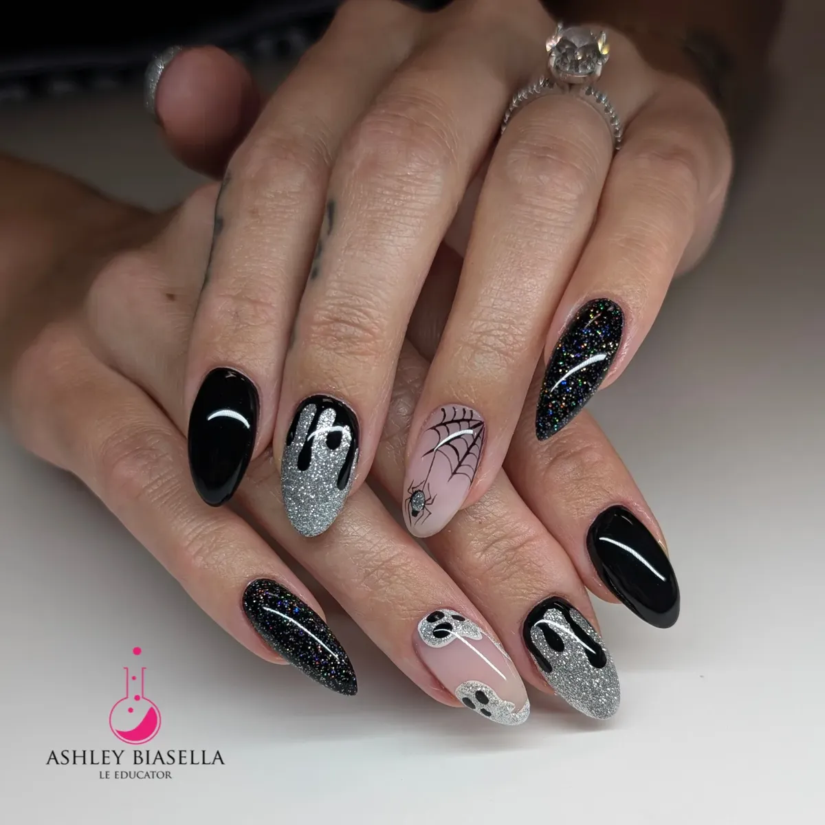 Black, silver glitter, and nude mix with drips, web, and ghosts