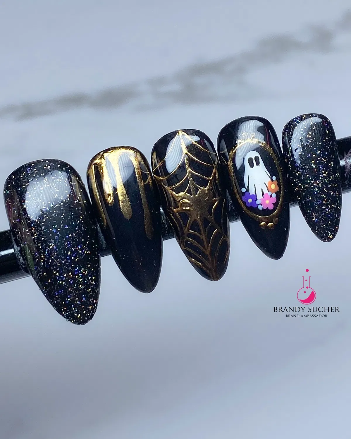 Black glitter and gold web accents with a ghost-and-flowers feature nail