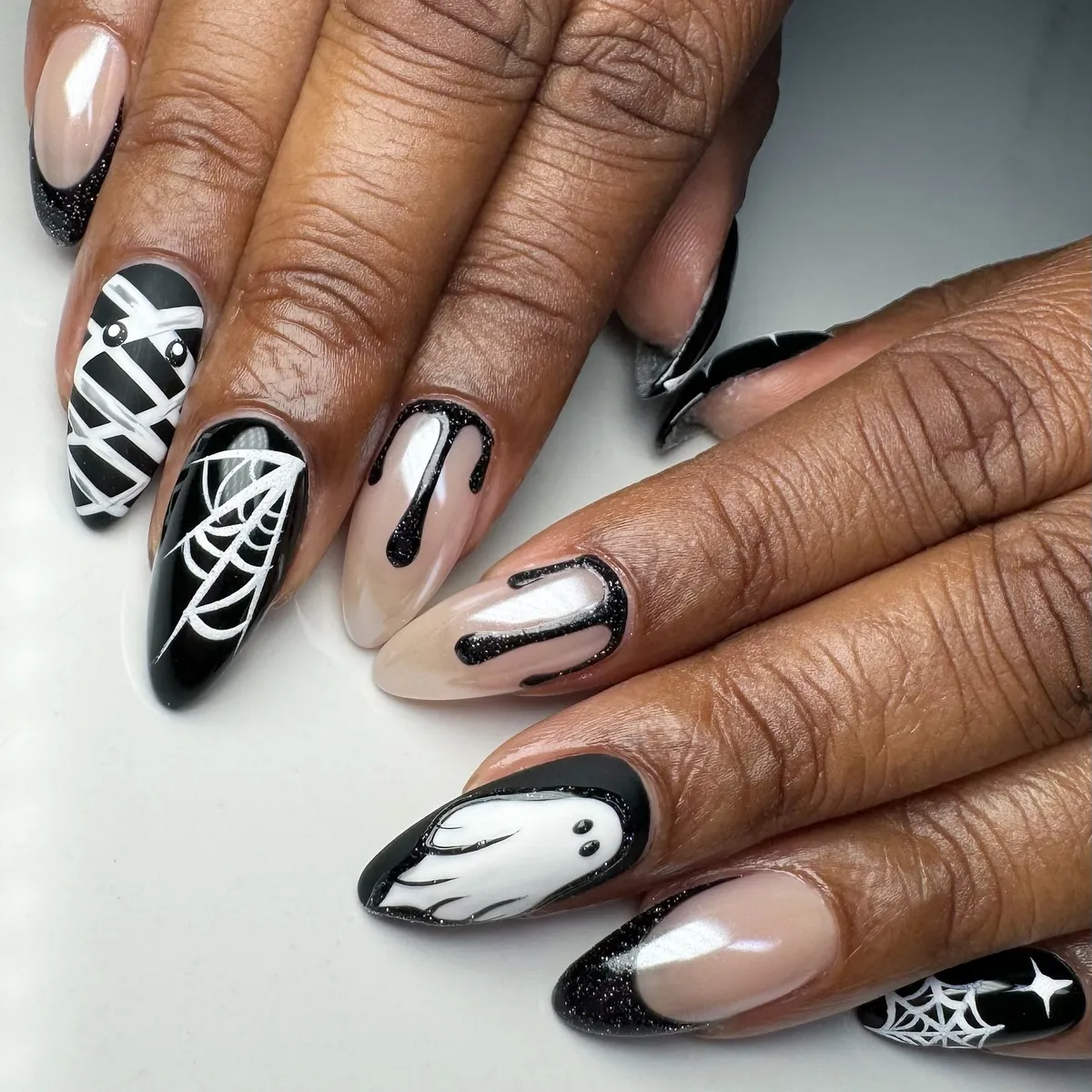 Black-and-white Halloween mix: web, ghost, drips, and glitter tips