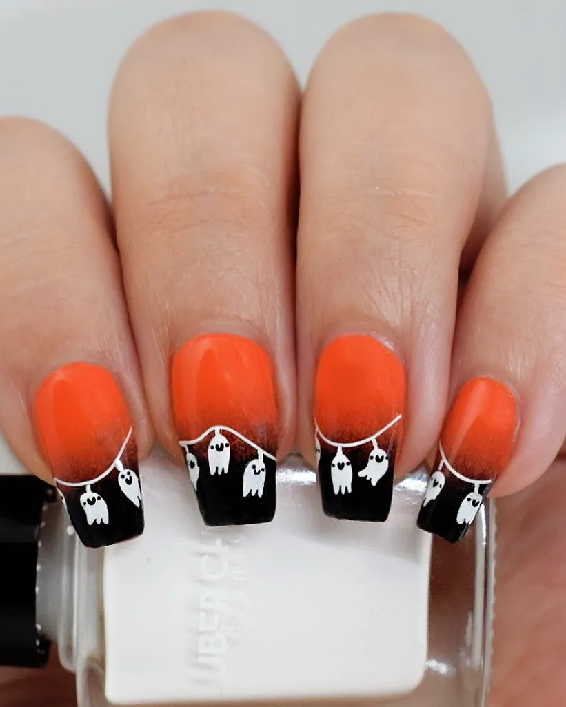 Orange-to-black ombrรฉ with hanging white ghost garland