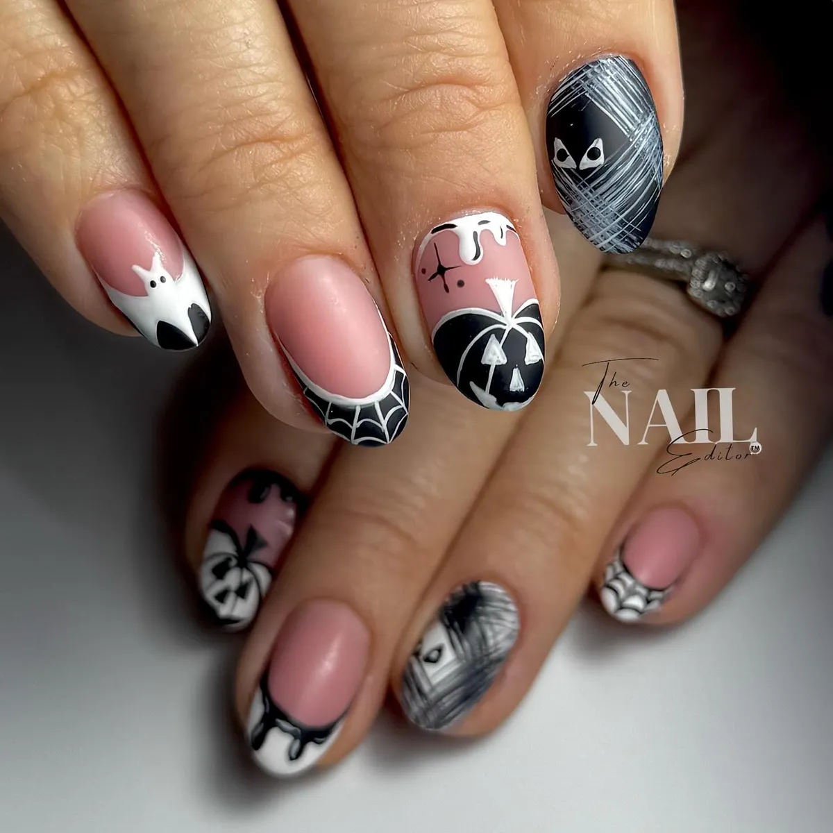 Pink base with black-and-white Halloween accents (cat, web, pumpkin)
