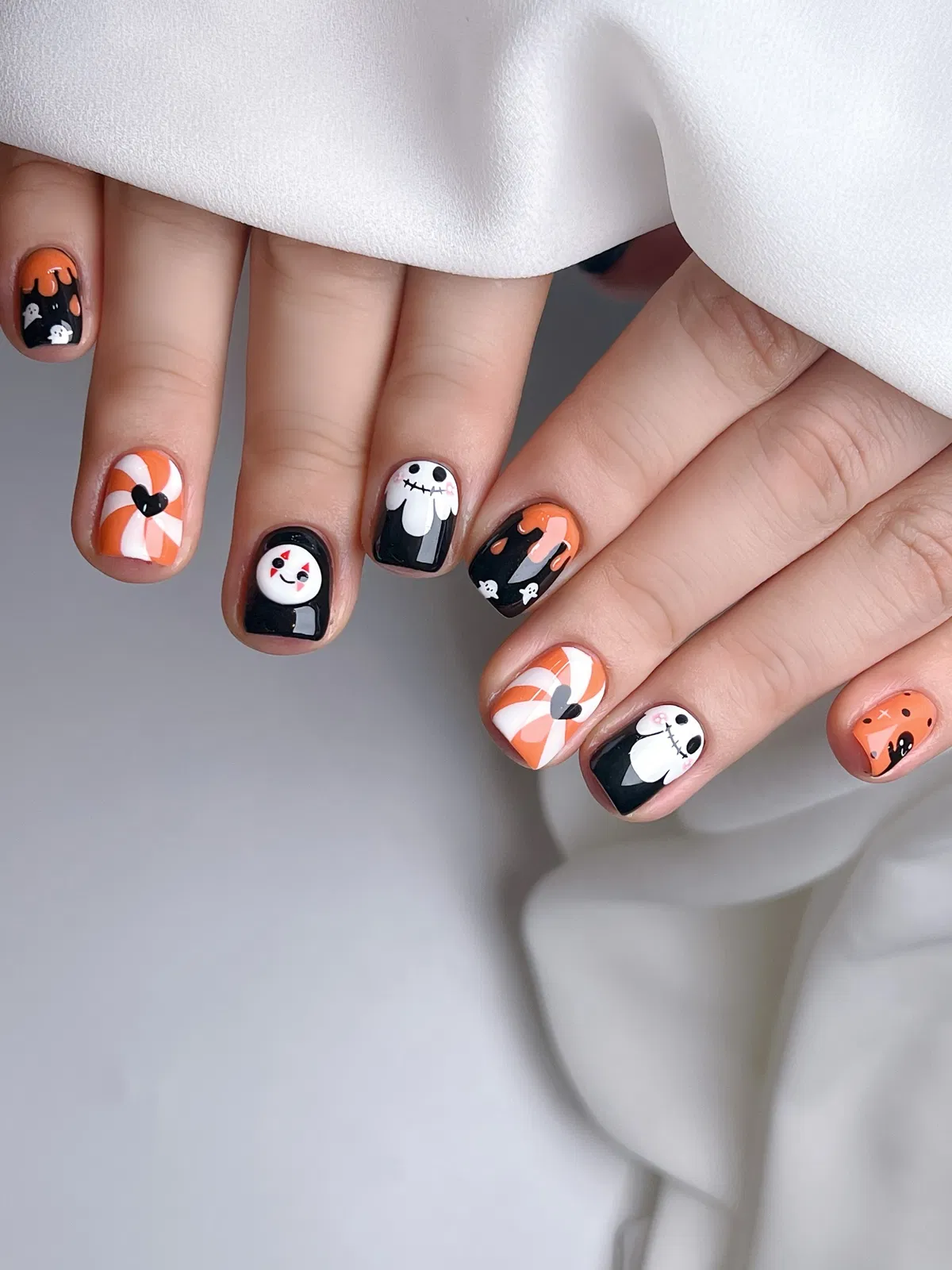Black-and-orange drips with swirl hearts and character-style accents