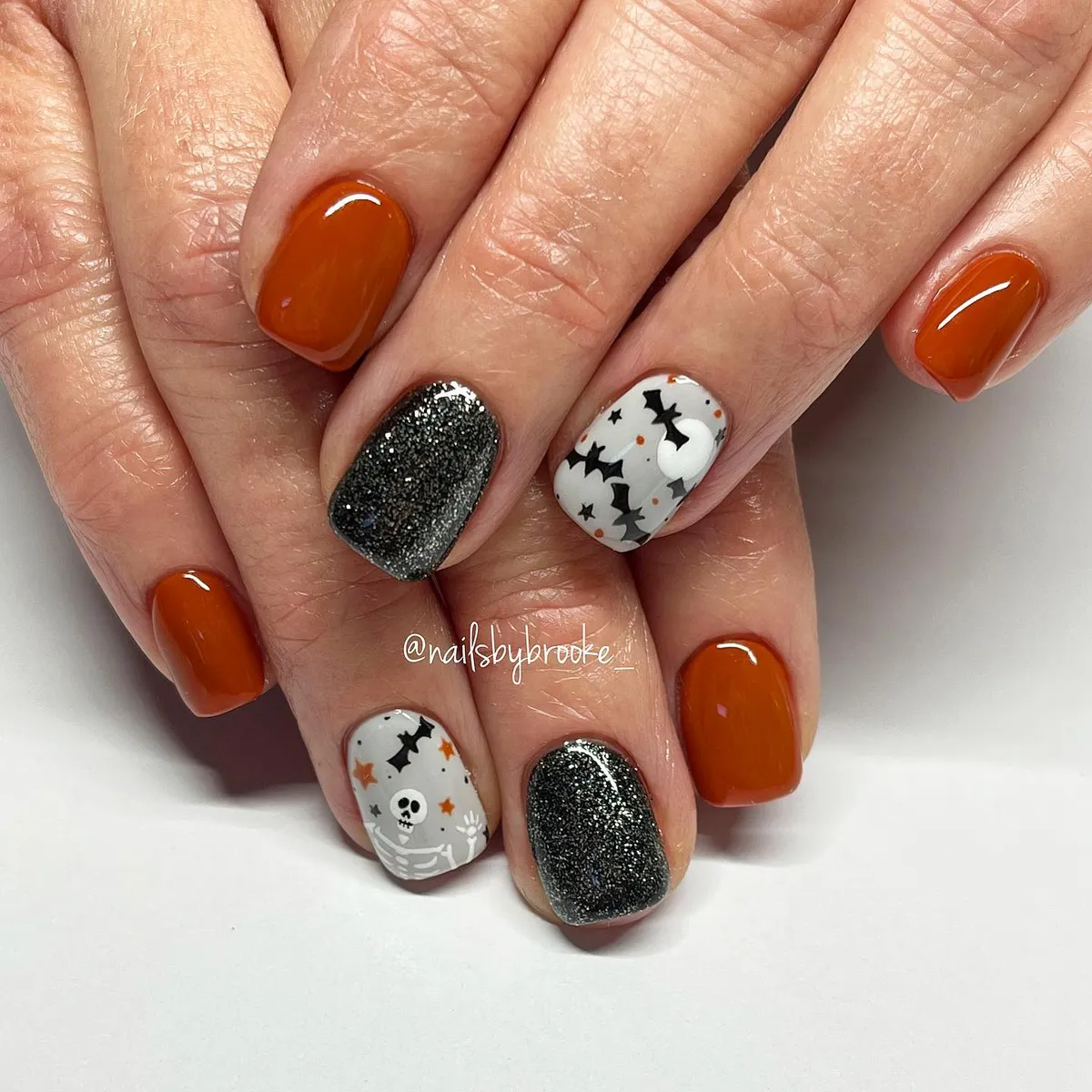 Burnt orange, dark sparkle, and white bat accents
