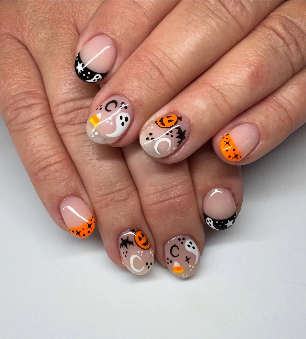Sheer nude base with tiny ghosts, bats, and orange accents