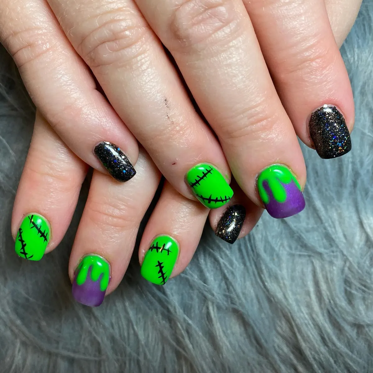 Neon green stitches with purple drips and black glitter