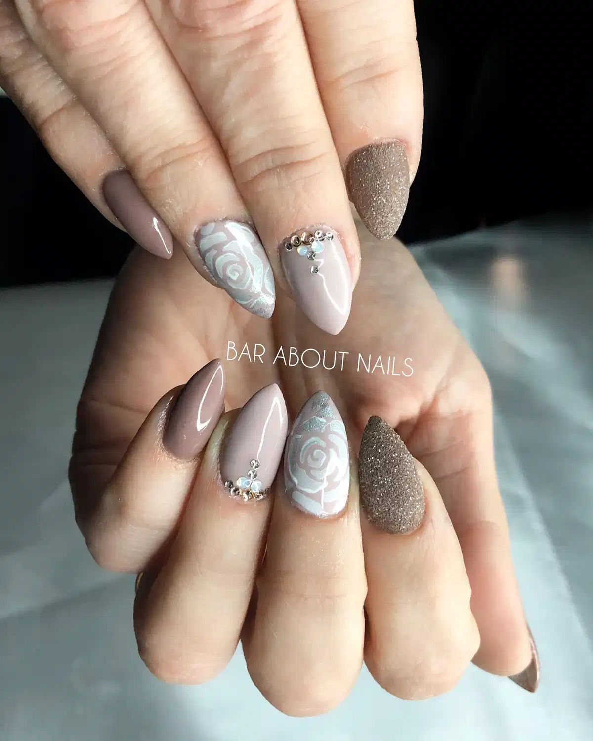 Taupe and Nude Almond Nails with Floral Line Art and Stud Accents