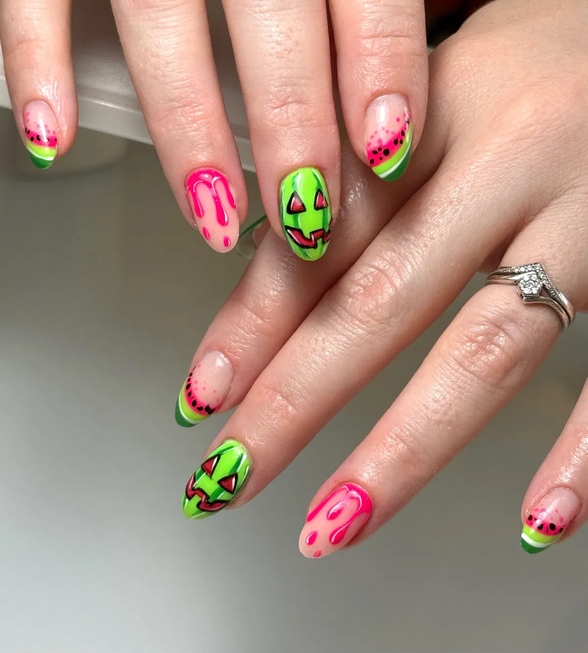 Neon green jack-o'-lantern faces with pink drips and seed-like dots