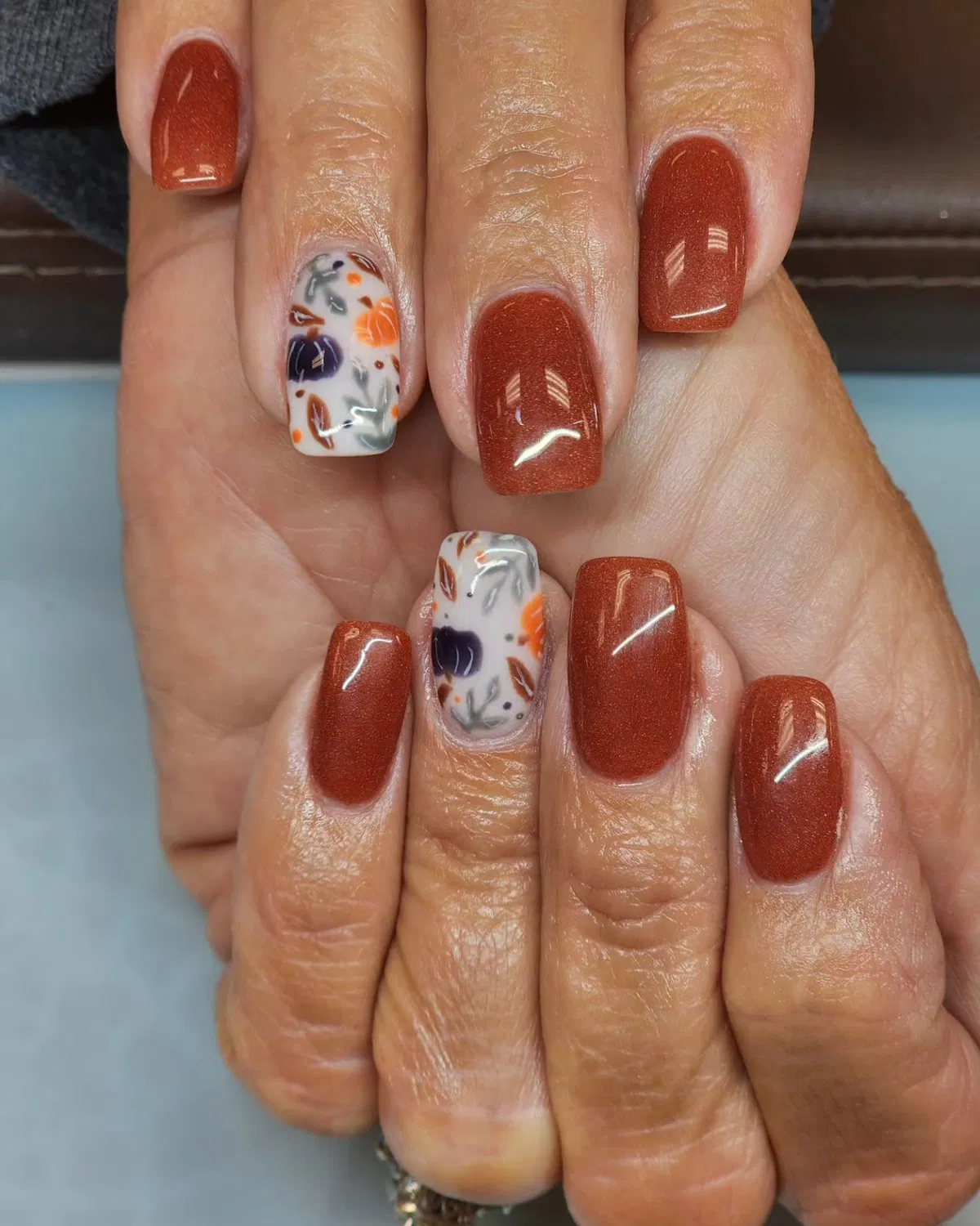 Shimmery rust-brown with white floral accent nails