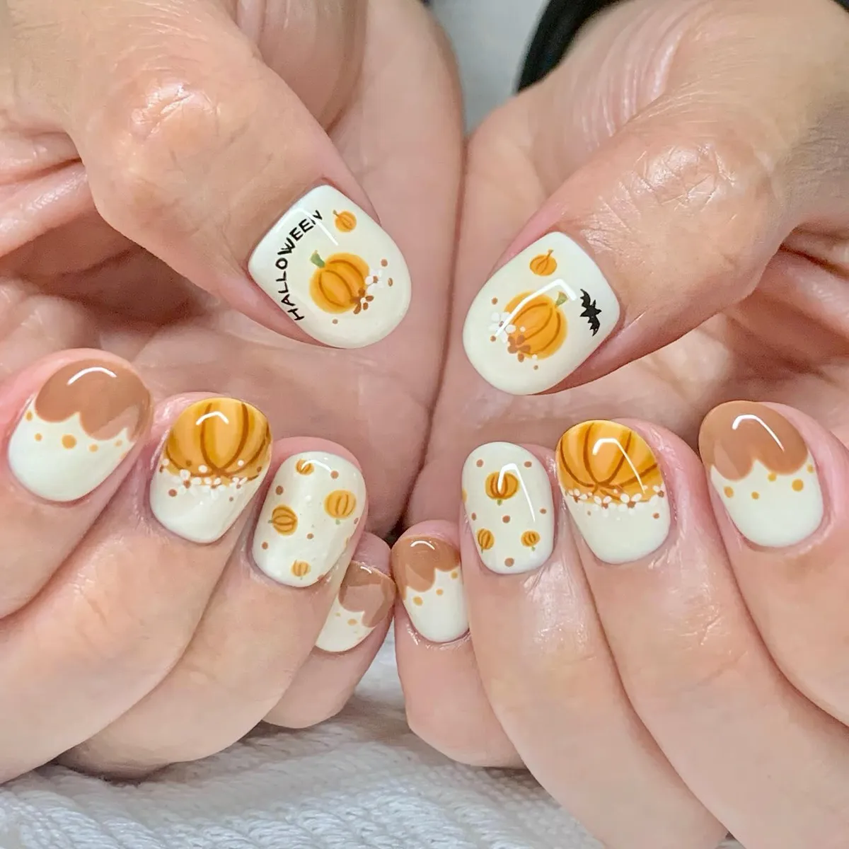 Cream pumpkin nails with Halloween text and bat detail
