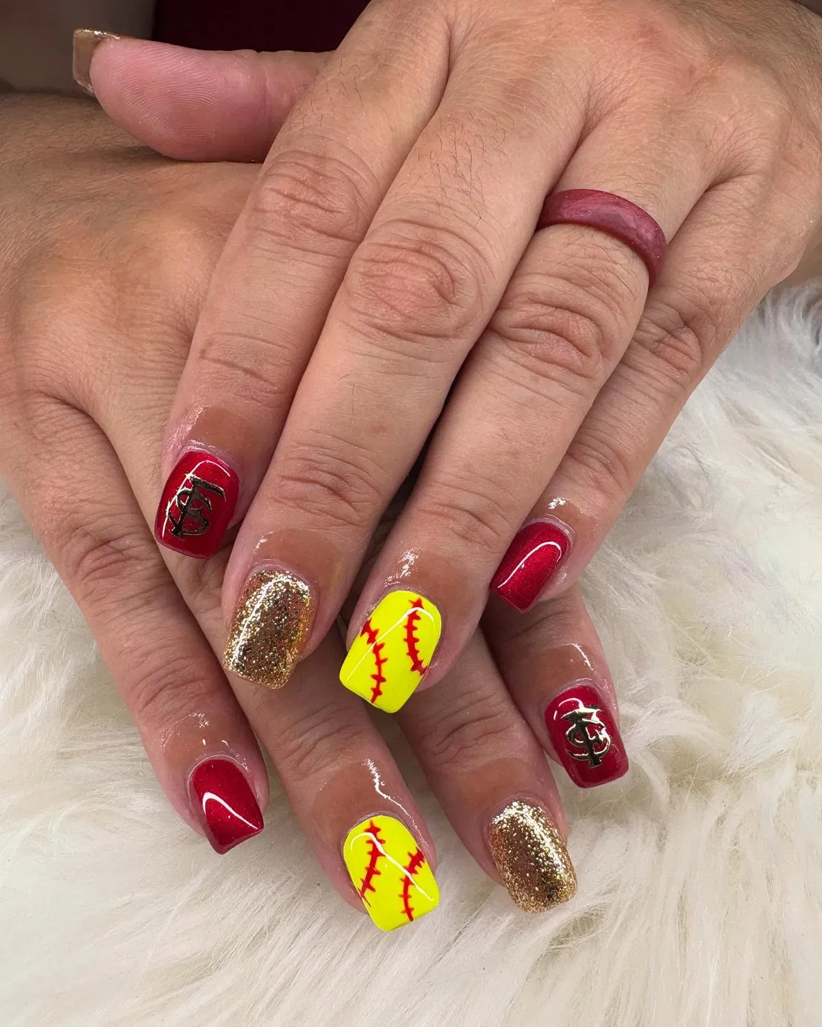 Red, gold glitter, and yellow seam-detail nails