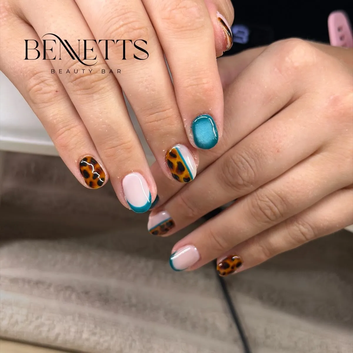 Teal French tips with leopard-spot accents