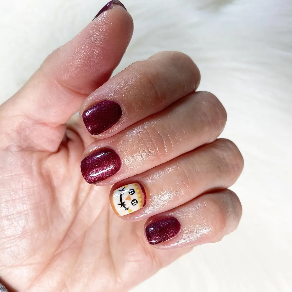 Deep burgundy with a single illustrated accent nail
