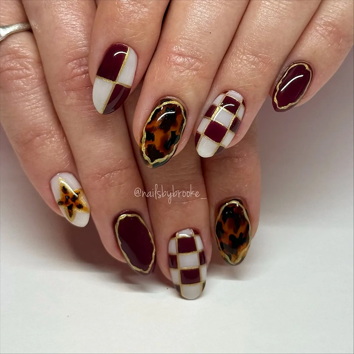 Burgundy, tortoiseshell, and gold-outlined grid accents